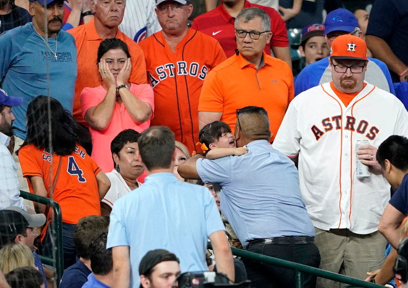 A young girl is carried from the stands after being hit by a foul ball in Houston.